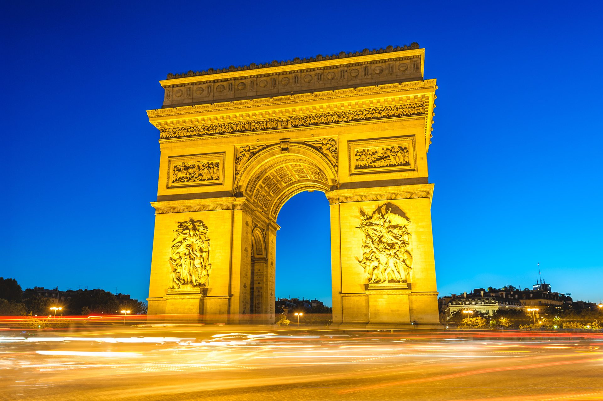 The Arc de Triomphe at night with streaks of traffic light circling it