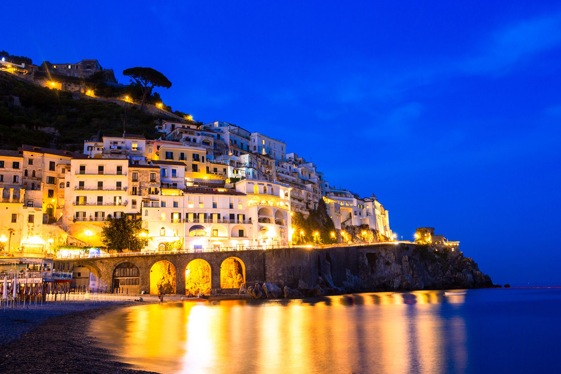An Amalfi Coast town lit up at night beside the sea