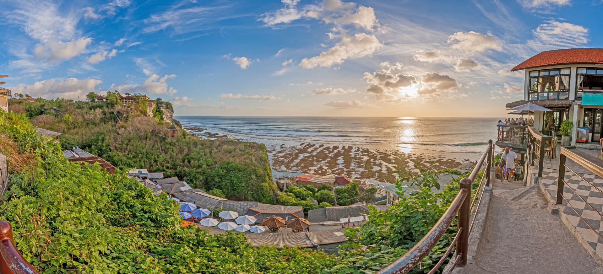 A panoramic sunset over the Bali coast seen from a terrace
